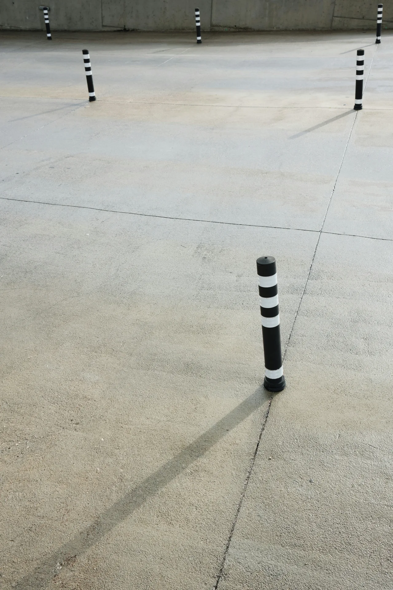 broom-finished concrete parking lot with bollards in Regina