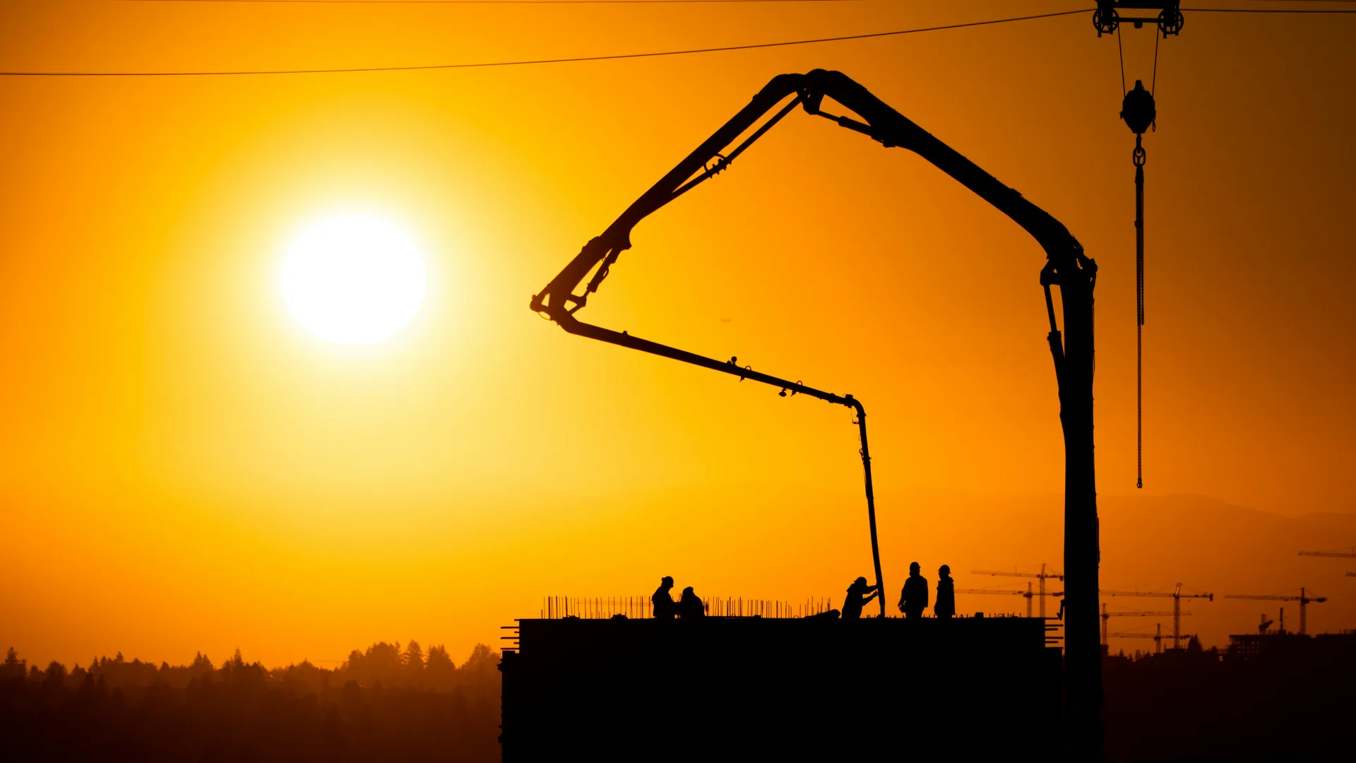 concrete boom pump on a Regina construction site at sunset
