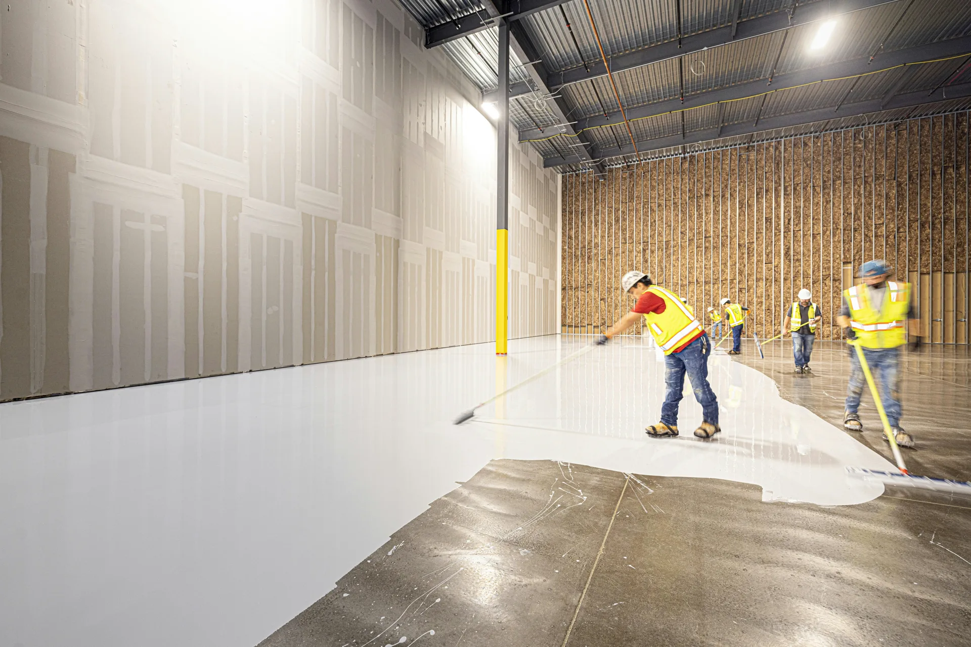 Rust-Oleum coating crew squeegeeing a base coat in Regina