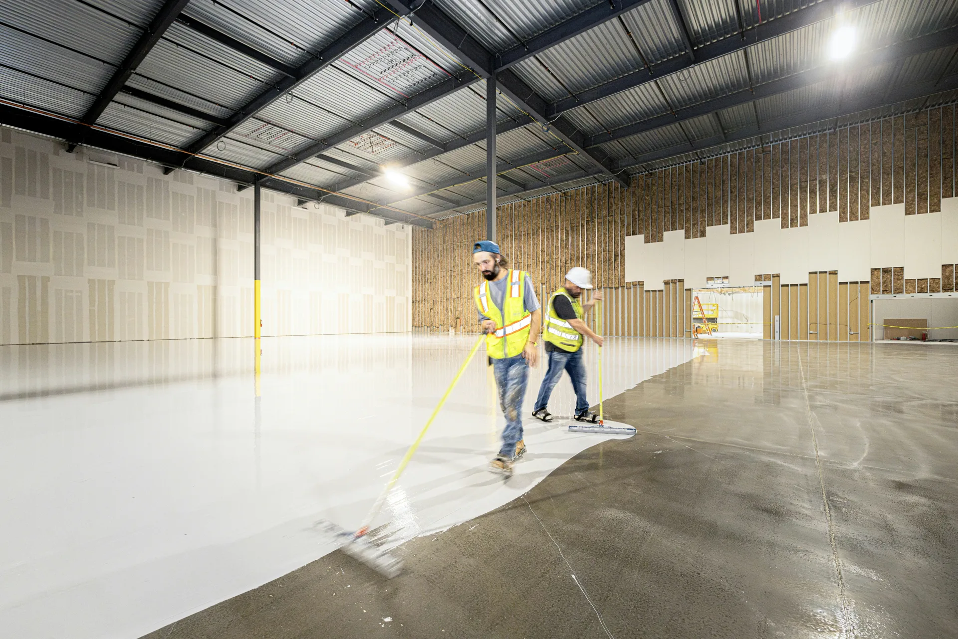 crew rolling epoxy onto a Regina garage floor