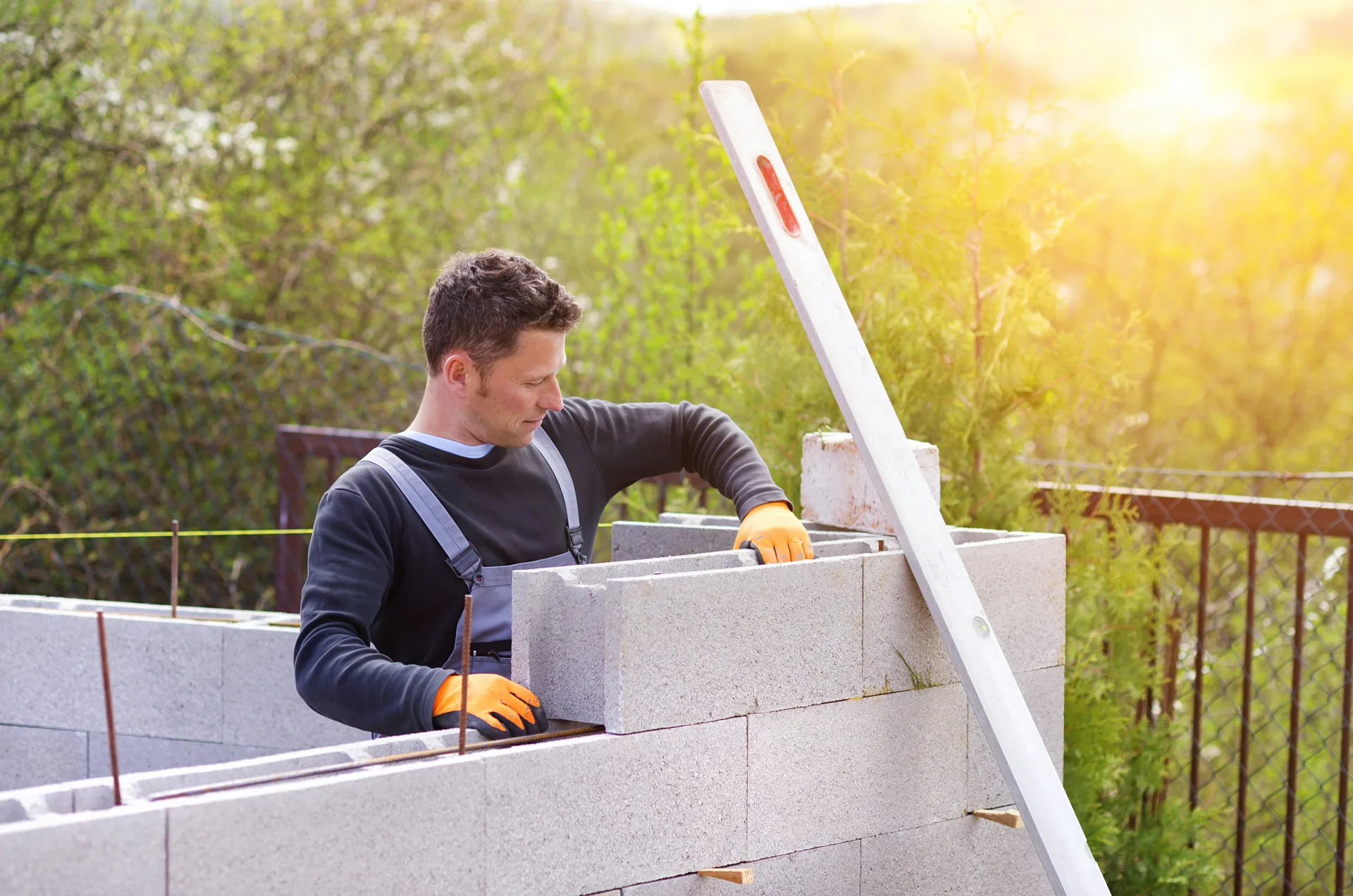mason levelling a block retaining wall at a Regina property