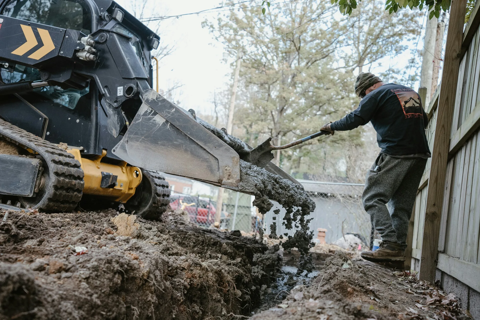 concrete foundation footing pour with a skid steer at a Regina site