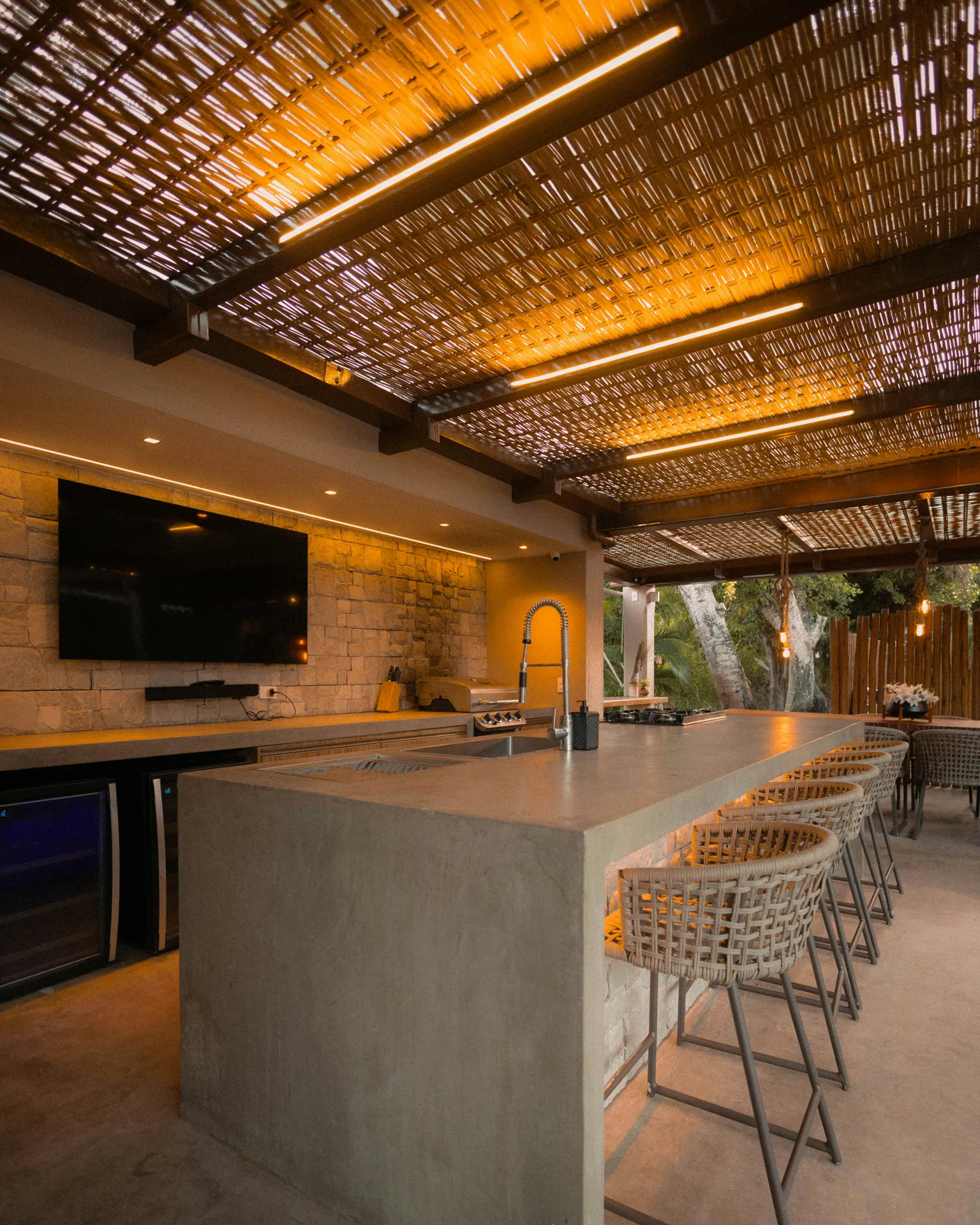 concrete outdoor kitchen bar under a pergola at a Regina home