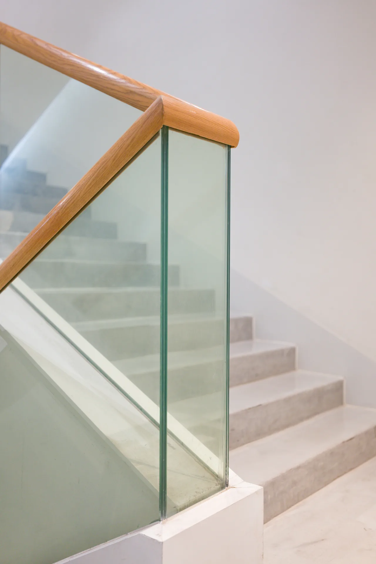 poured concrete staircase with glass railing at a Regina home